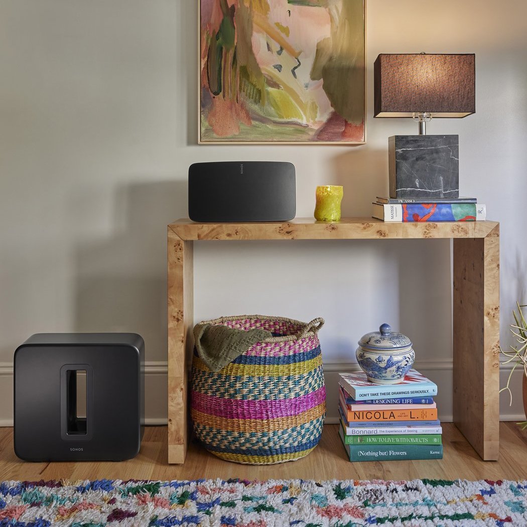 Sub lautsprecher auf dem Boden mit verschuiedenen Inneneinrichtungsgegenständen